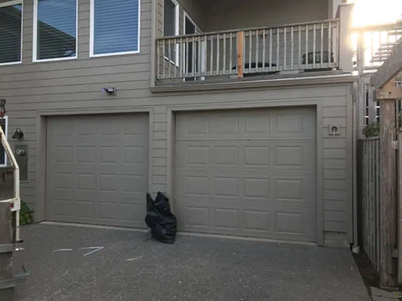 Before: plain garage doors on a duplex