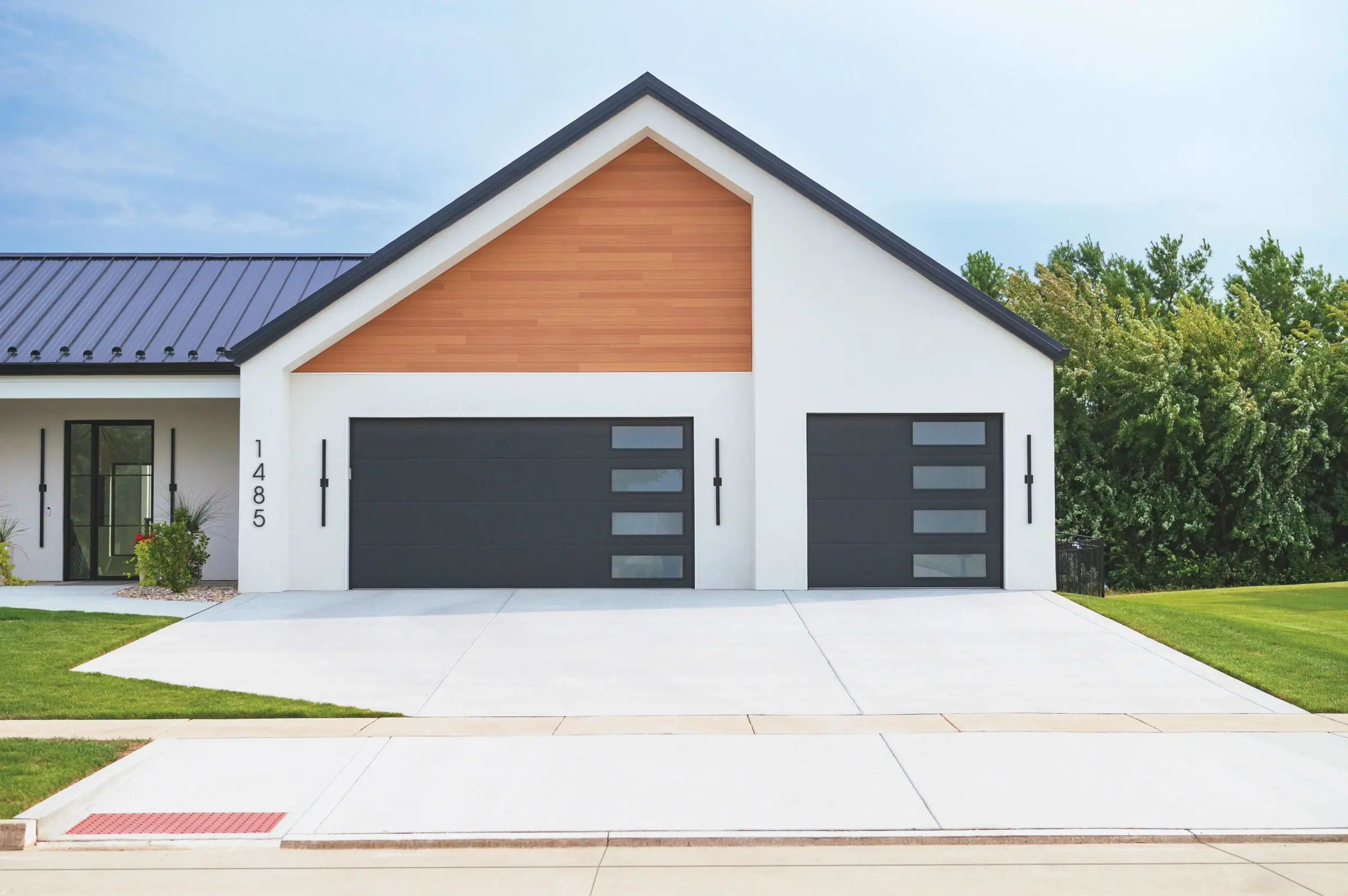 Black full-view garage doors on a modern white home