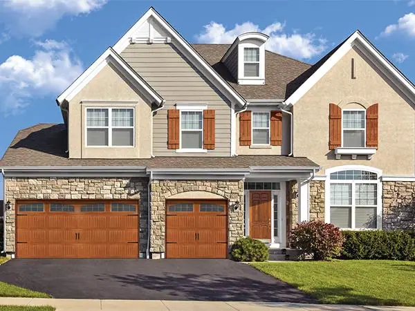 Two wood-look carriage garage doors on a craftsman home